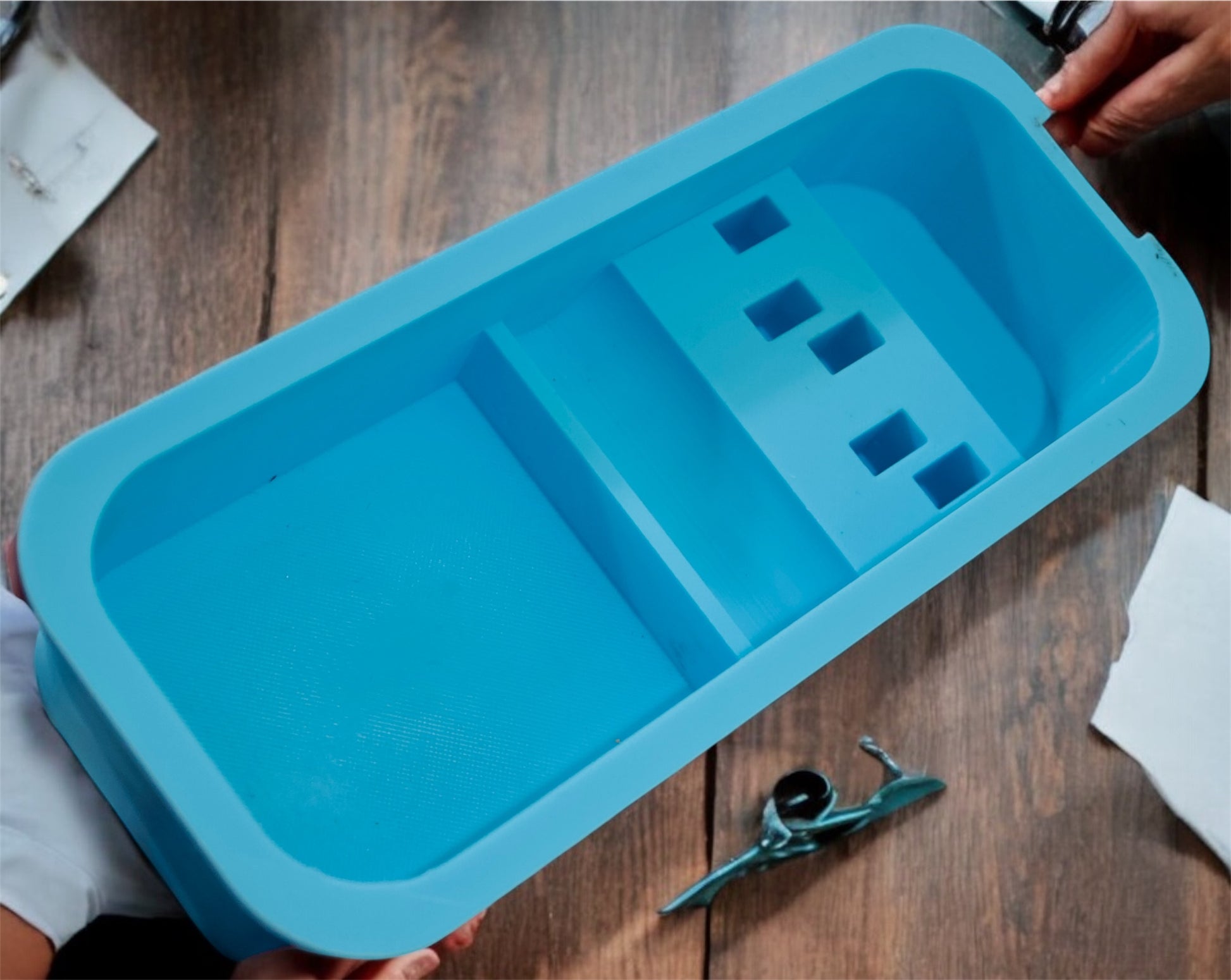 Blue plastic tray with compartments on a wooden surface