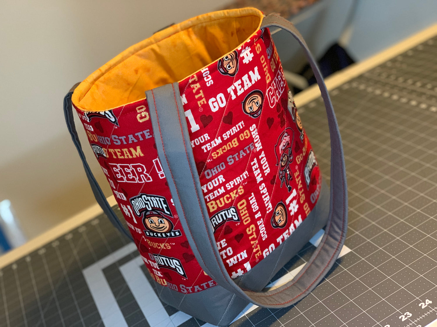 Red tote bag with Ohio State University-themed design on a cutting mat.