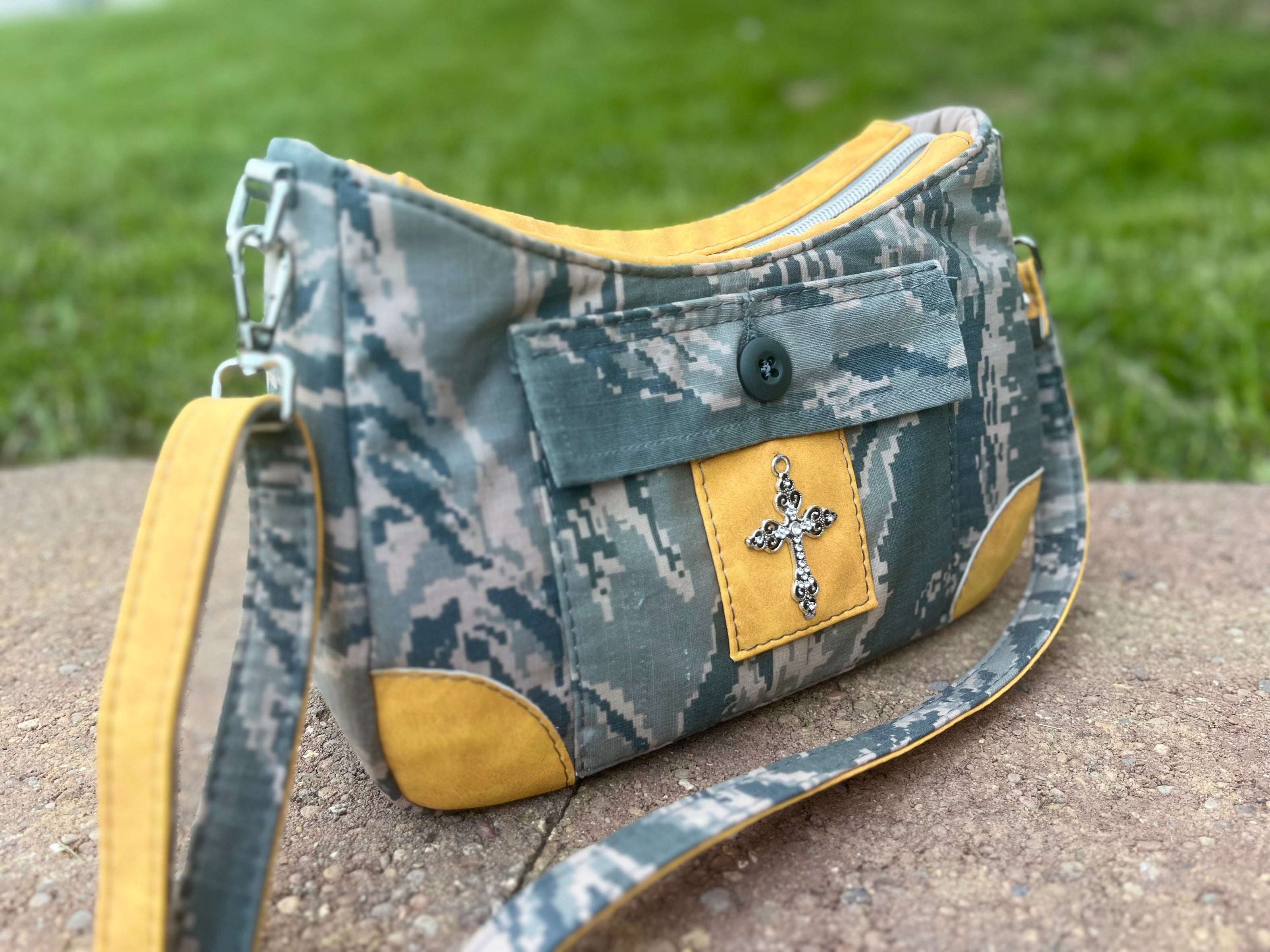 Measure and Cutt Camouflage-patterned handbag with yellow accents on a stone surface