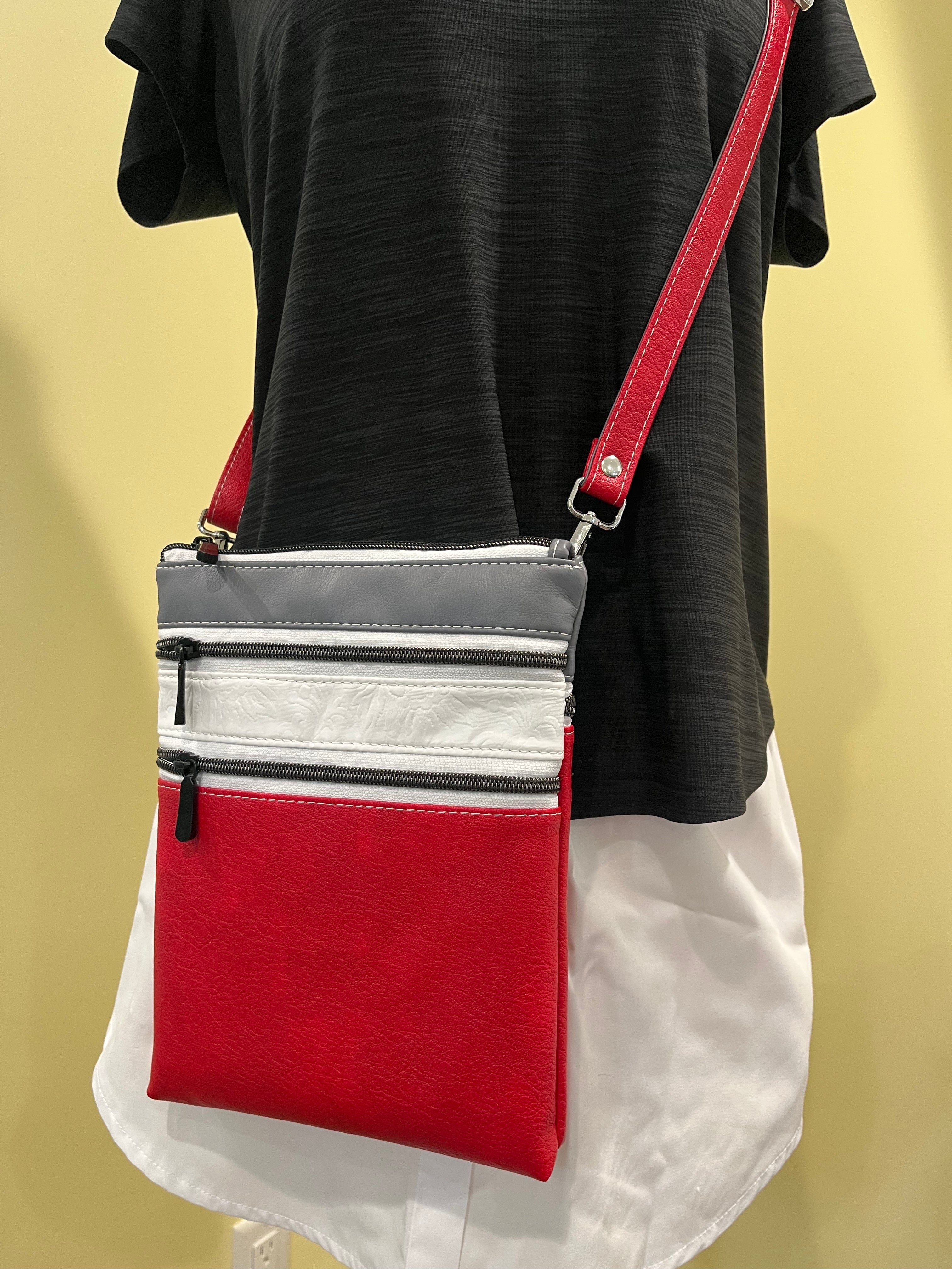 Measure and Cutt Red and gray crossbody bag worn by a person on a yellow background