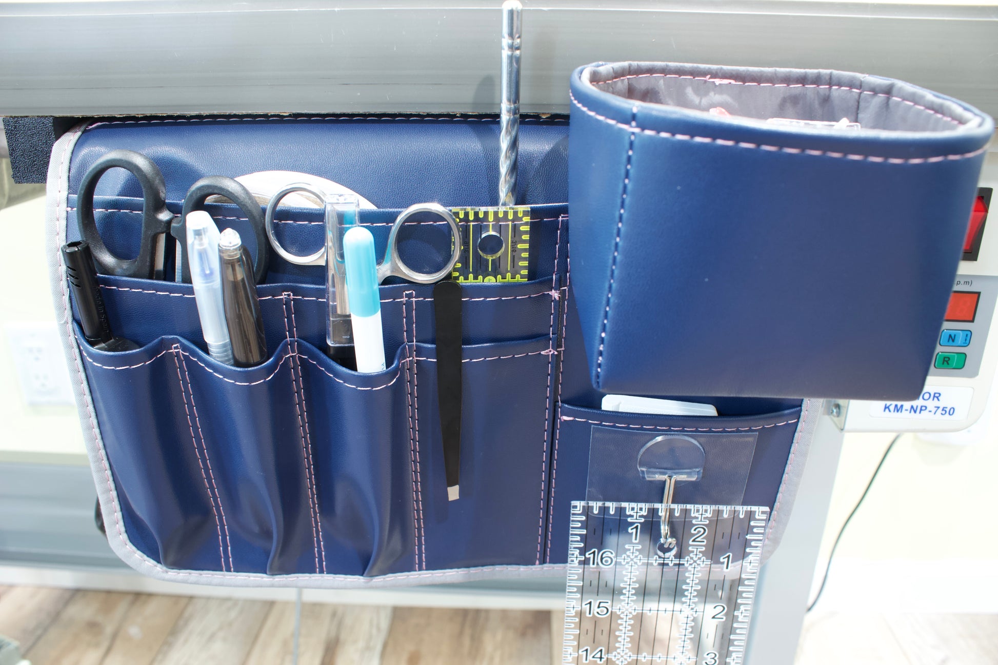 Molly Caddy Blue tool organizer with various items on a light gray table