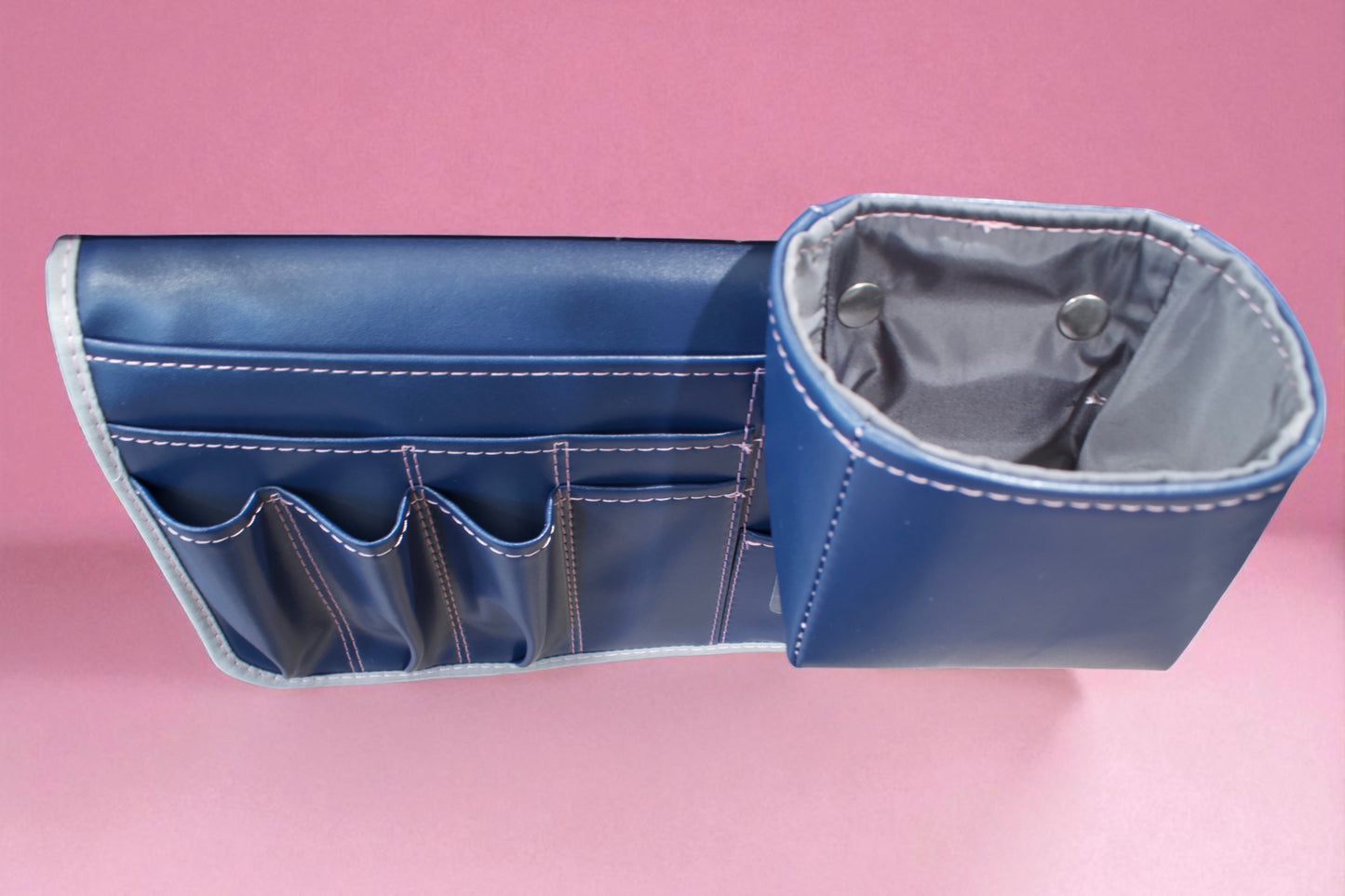 Molly Caddy Blue vinyl organizer with gray interior on a pink background