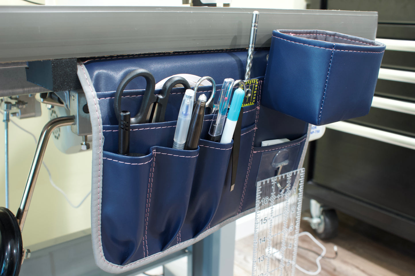 Molly Caddy Blue tool organizer hanging on a metal surface with various tools inside