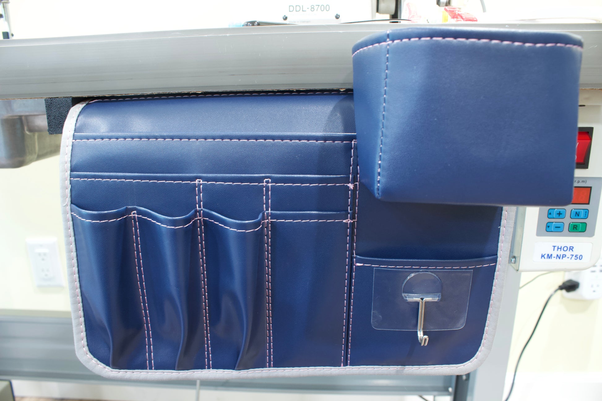 Molly Caddy Blue tool organizer with multiple pockets on a sewing table